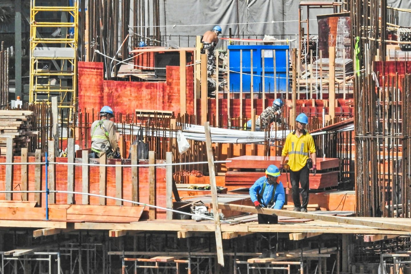 Operai edili in tenuta di sicurezza costruiscono una struttura a più piani.