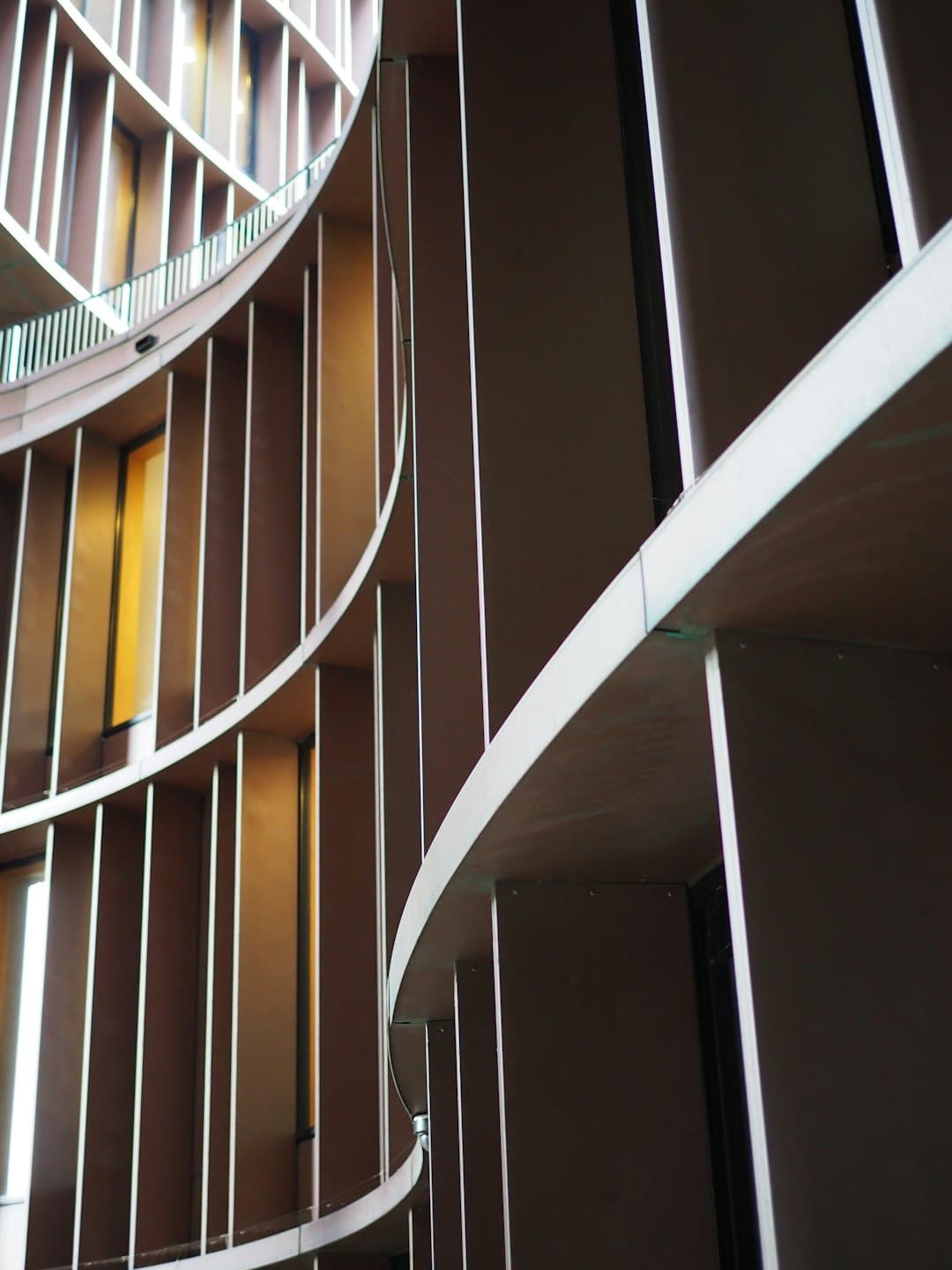 Interno di un edificio moderno con pareti curve e lamelle verticali.
